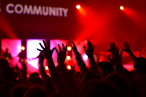 Community gathering with people raising hands.